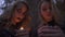 Two caucasian blonde women with halloween makeup holding small candles in hands and looking at the camera. Gothic horror