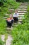 Two caucasian boys sitting on a stone staircase outdoors in summer