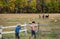 Two caucasian farm cowboys walking by a fence acting silly.