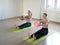 Two caucasian girls practise pilates with small fit balls, in fitness studio, loft style, selective focus.