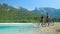 Two Caucasian guys ride their bikes up to a stream and observe the landscape.