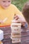 Two Caucasian kids is playing wood blocks tower game for practicing physical and mental skill.