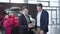 Two caucasian men standing in car dealership and talking. Car dealer holding tablet and consulting client in showroom