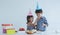 Two Caucasian sibling little sister feeding brother birthday cake at mouth with hands at home on white background