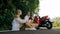 Two caucasian tourist woman man sit near red scooter. Make it selfie. Love couple on motorbike in white clothes on