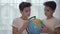 Two Caucasian twin brothers looking at globe and talking. Siblings studying together at home. Education, geography