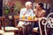 Two caucasian women, elderly and young, talking, looking each other, smiling