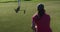 Two caucasian women playing golf one kneeling looking at ball