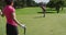 Two caucasian women playing golf one taking shot from bunker