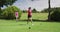 Two caucasian women playing golf one taking shot from bunker