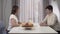 Two Caucasian women sitting at the table and talking. Mother and adult daughter spending time together at home. Leisure