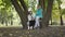 Two caucasian women sitting on the tree in the autumn park and discussing the book. Nice brunette woman explaining