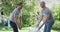 Two caucasian young male volunteers collecting plastic material in a bag and high fiving each other