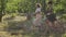 Two caucasian young women walking outdoors. Girls talking while leading their bicycles on the narrow road on the street