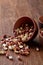 Two ceramic bowls with raw peanuts mix over rustic wooden backround, top view, close-up.