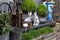 Two ceramic hares among boxwood bushes and garden grass. Trolley on wheels and miscellaneous gardening utensils - lanterns