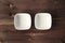 Two ceramic white small bowls at the rustic wooden table