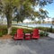 Two chairs sitting in a park by a lake in Laurete Park in Lake Nona, Orlando, FL on a beautiful sunny day