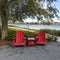 Two chairs sitting in a park by a lake in Laurete Park in Lake Nona, Orlando, FL on a beautiful sunny day