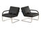 Two chairs worn black leather on a metal base on a white background 3d rendering