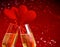 Two champagne flutes with golden bubbles and red velvet hearts make cheers on red bokeh background