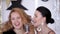 Two charismatic girls in evening dresses sing at a party
