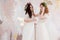 Two charming brides in beautiful spring wreaths on their heads. Beautiful young women in wedding dresses.