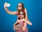 Two charming happy sisters in sunglasses taking selfie using smartphone