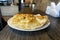 Two chebureks fried meat patties on a white plate served in a cafe. Traditional Crimean Tatar cuisine. Selective focus