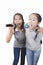 Two cheerful asian teenager singing with microphone  isolated white background