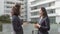 Two cheerful business ladies standing outside