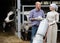 Two cheerful farmers holding a trolley with milk