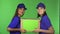 Two cheerful female delivery service workers smiling holding cardboard box