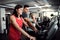 Two cheerful female seniors in gym with a young trainer doing cardio work out.