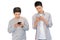 Two cheerful friends wear gray t-shirts standing isolated over white background, holding mobile phone.Couple of cool guys using