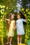 Two cheerful girls walk through a beaded curtain in nature