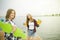 Two cheerful happy skater girls in hipster outfit having fun on a wooden pier during summer vacation