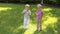 Two cheerful little brothers play with soap bubbles in the park on green grass.