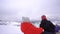 Two cheerful schoolgirls enjoy sledding down the mountain during winter break. Ski resort in the Carpathians during