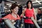 Two cheerful seniors women in gym doing strength workout exercise.