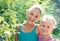 Two cheerful sisters playing in the park in warm summer day