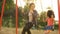 Two cheerful sisters swinging together at outdoor child playground, happiness