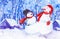 Two cheerful snowmen in a red scarf, red mittens and a black hat stand against the background of falling snow in the village. New