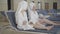 Two cheerful wealthy ladies in white bathrobes and hair towels laughing and chatting in luxurious spa resort. Positive