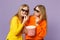 Two cheerful young blonde twins sisters girls in 3d imax glasses watching movie film, hold popcorn isolated on pastel