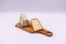 Two cheese wedges wrapped in an individual plastic package at home. Small wooden cutting board. White background