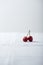 Two cherries on the white linen tablecloth