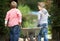 Two Childen Playing With Wheelbarrow In Garden