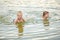 Two children bathing in water of sea