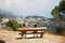 Two children, brothers, sitting on a bench, watching the village underneath from the mountains